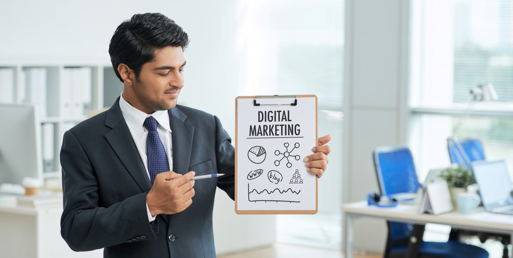 man-suit-standing-office-with-clipboard-pointing-poster-with-words